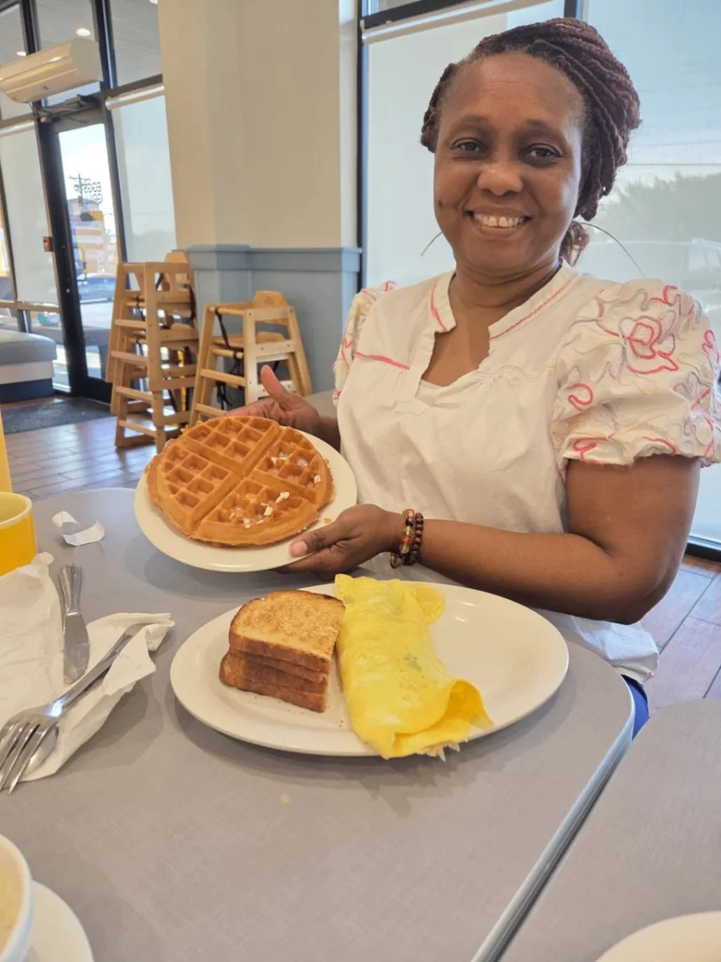 Team member smiling while holding a waffle