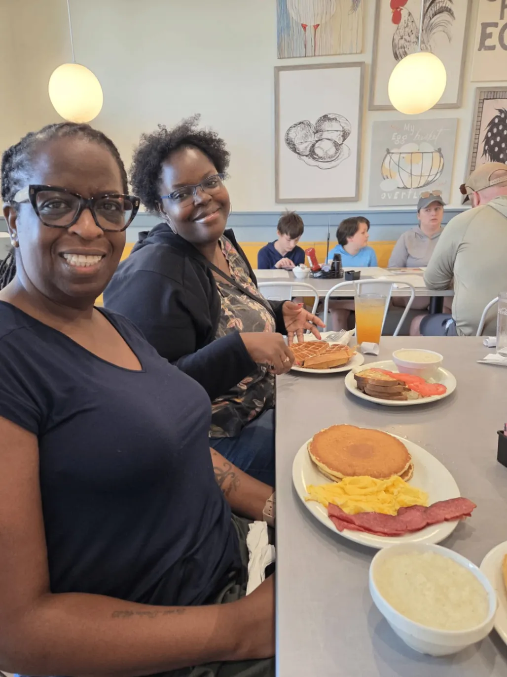 Two team members smiling together over a meal